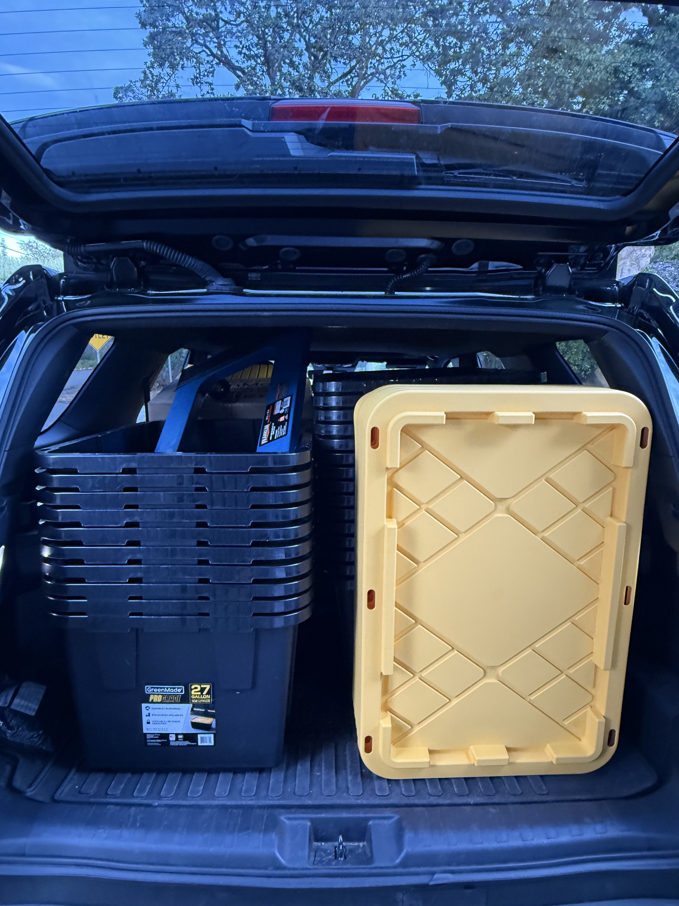 Cascade moving totes, lids, and a furniture dolly loaded for delivery